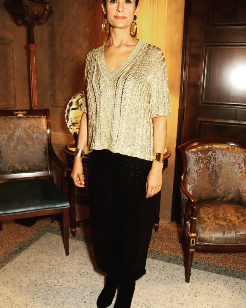 Livia Firth usando seu look elegante preto e dourado